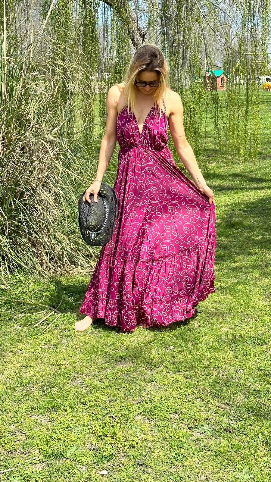 Model outdoors wearing the Asia Dress , a fuchsia silk maxi dress with open back, one size