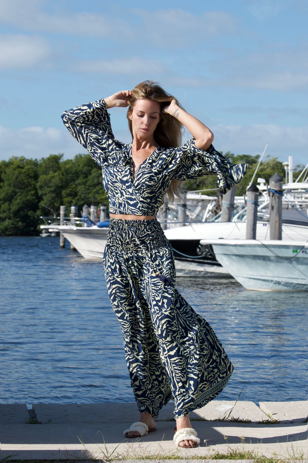 Model by the marina wearing the Berry Set, a blue and cream silk pants and crop top, one size