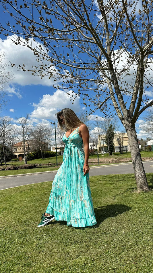 Model outdoors wearing the Dorothy Dress, a green silk maxi dress with front tie, one size