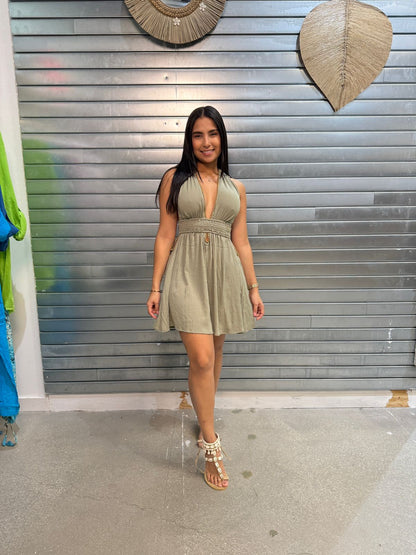 woman wearing short green rayon dress with golden bead details in store setting