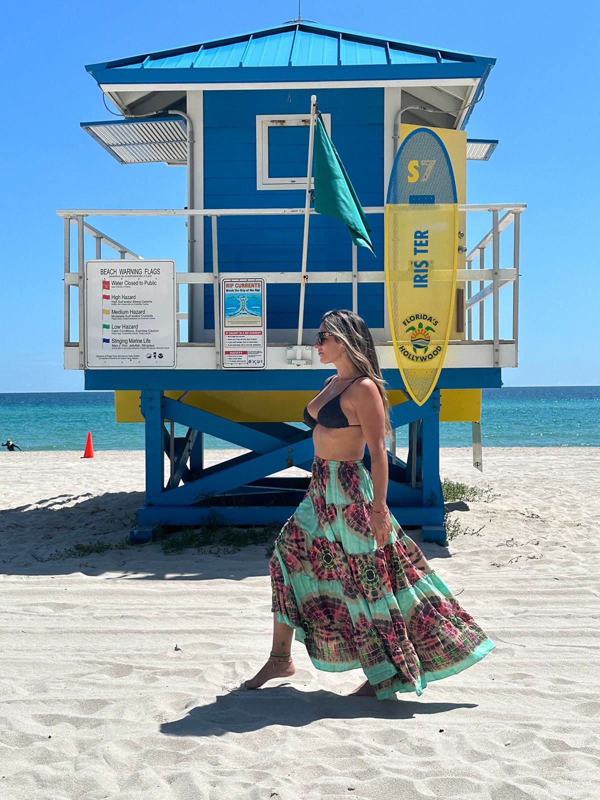 Side view of model wearing a multicolor long Skirt with triangle top on the beach