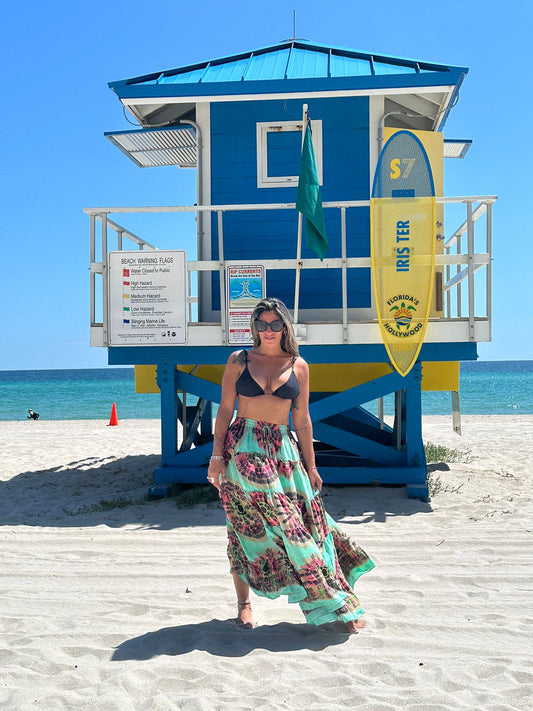 Model on the beach wearing a colorful long skirt with elastic waistbang