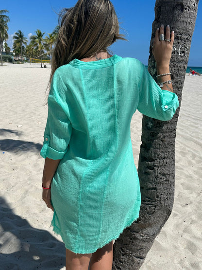 Back view of model wearing short green cotton shirt dress with sequins detail, beachwear style