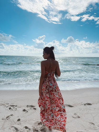 Back view of model at the beach wearing a multicolor silk maxi dress with open back tie