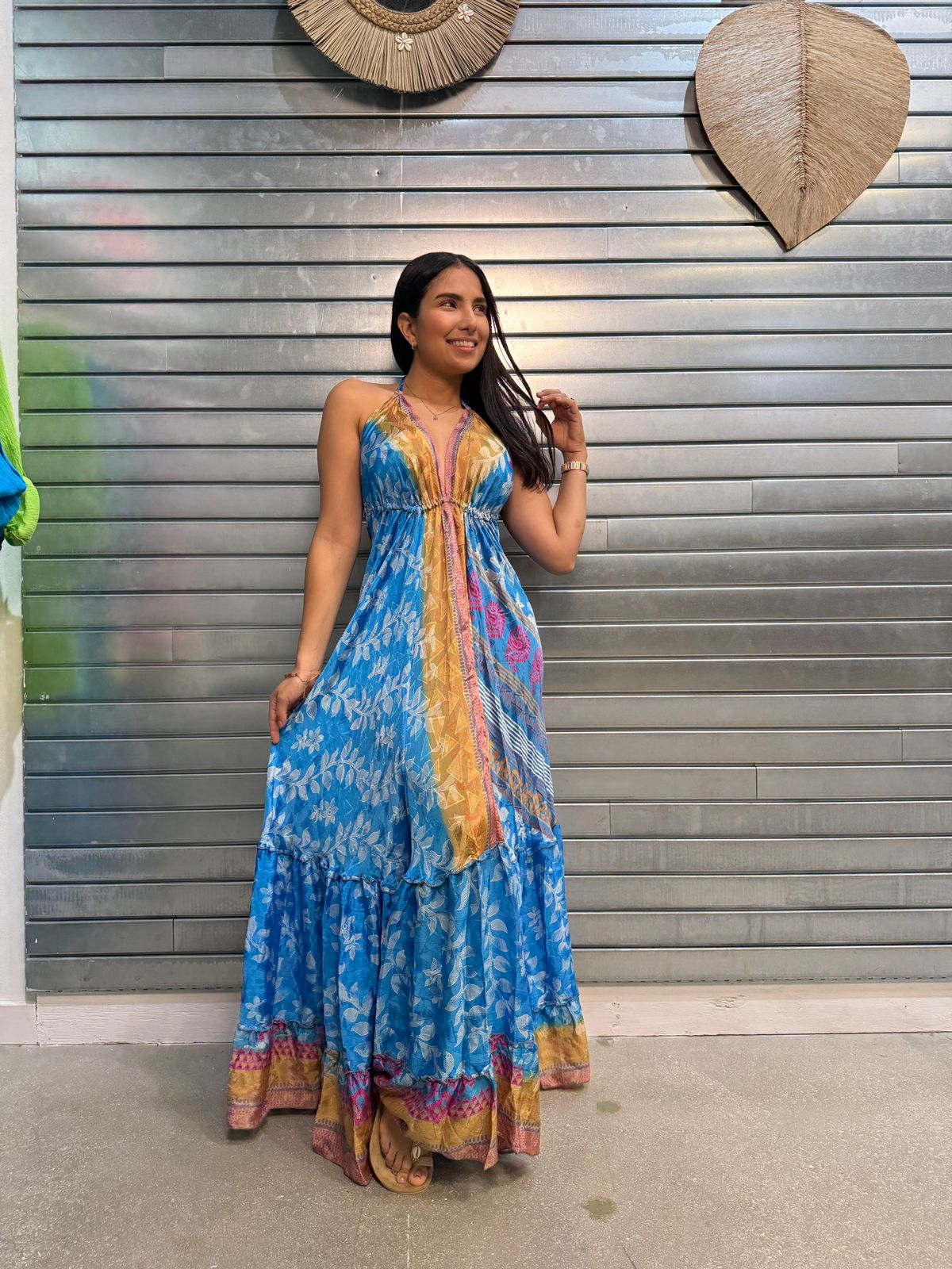 woman wearing long blue floral dress with open back, one size, perfect for summer and events