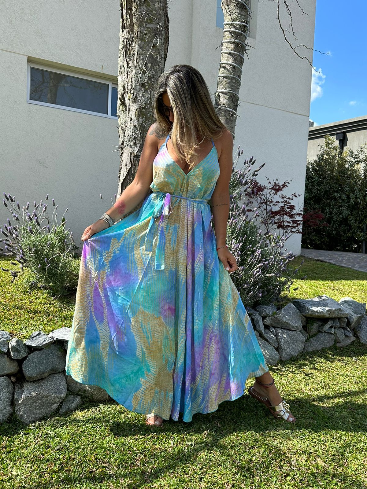 MODELO LUCIENDO VESTIDO ALRGO CON ESCOTE EN ESPALDA Y ATADO AL FRENTE 