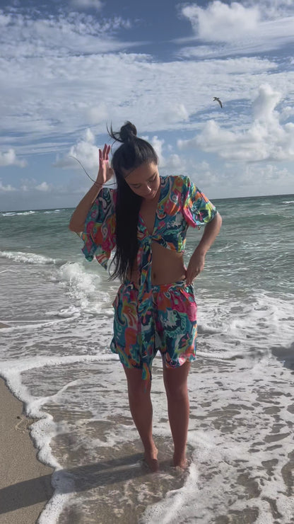 Video of model walking on the beach wearing the selena set, multicolor silk short and crop top, one size